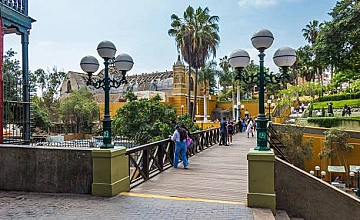 Puente de los Suspiros en Barranco, Lima, con faroles, jardines y visitantes caminando